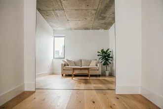 Grand miroir au sol dans un petit salon d'appartement urbain agrandissant visuellement l'espace